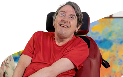 Hireup user Glenn smiles at the camera.