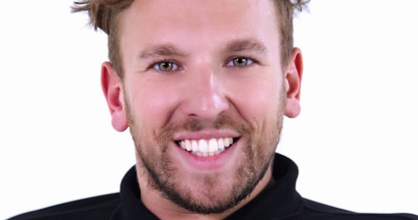 Dylan Alcott has messy blond hair. He is smiling broadly. He is wearing a black shirt