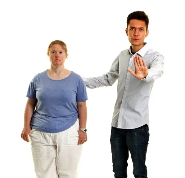 A man supporting a woman and holding his hand out to protect her