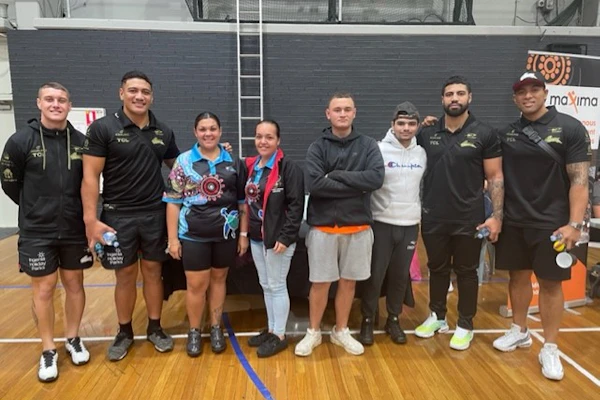 Kurranulla Aboriginal Corporation NDIS youth group clients pose in a line, smiling, facing the camera.