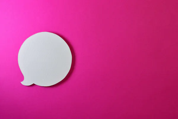 A white speech bubble sits on a bright pink background.