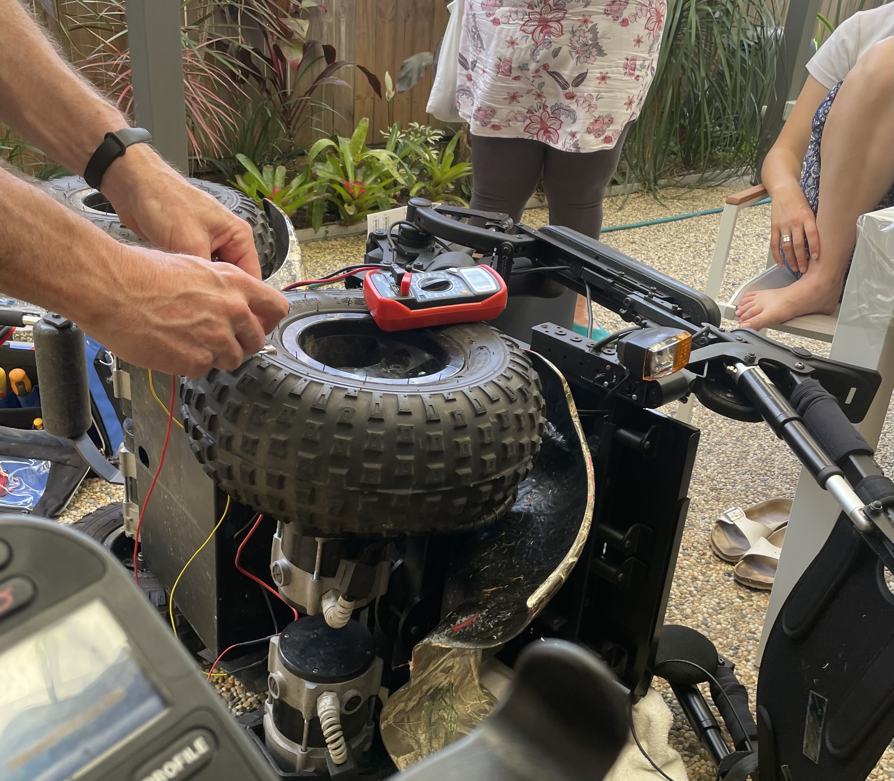 A power wheelchair is turned on its side to be fixed. 