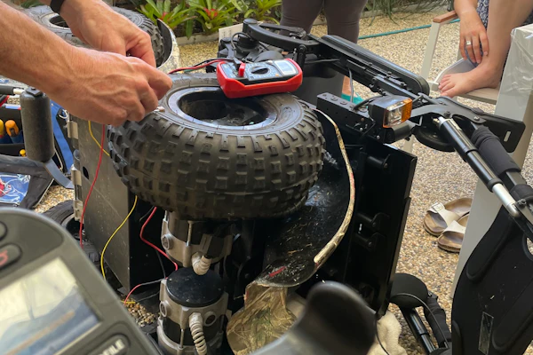 A power wheelchair is turned on its side to be fixed.