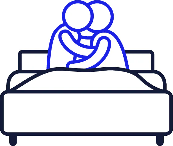 2 people holding each other and kissing in a bed.