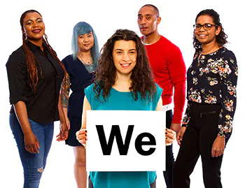 A group of people. There is a woman at the front of the group, she is holding a card that says we.