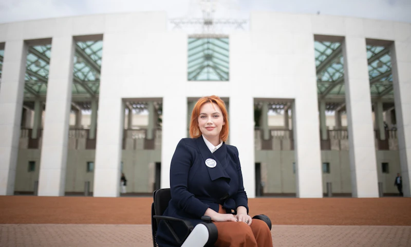 Elly Desmarchelier sits in front of Parliament House in Canberra, ACT.