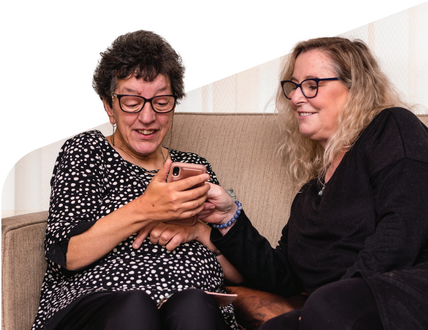 A Hireup user scrolling through their phone with their support worker.