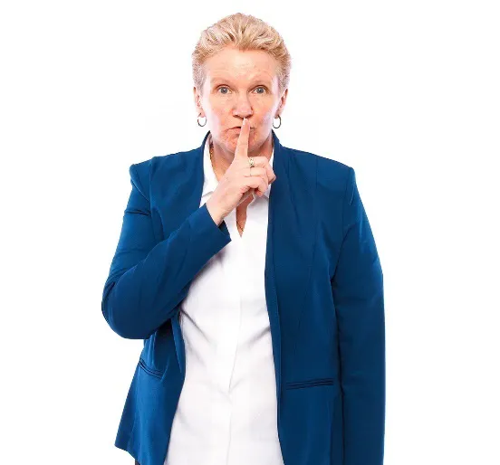 A woman with her finger up to her mouth to say be quiet 