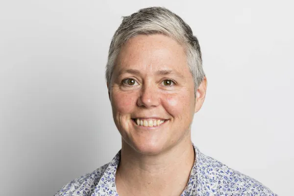 NDS CEO Laurie Leigh has short silver hair and smiles at the camera.