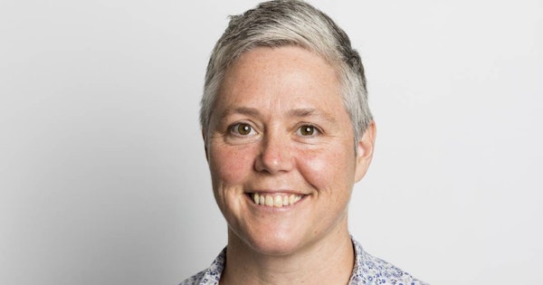 NDS CEO Laurie Leigh has short silver hair and smiles at the camera.