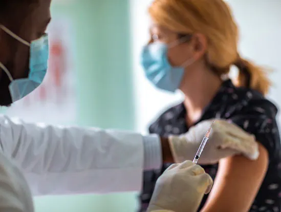 A woman receives a vaccine.