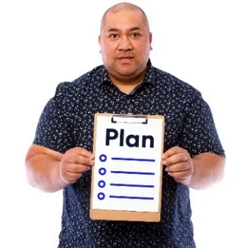 A man holds a clipboard that says plan.