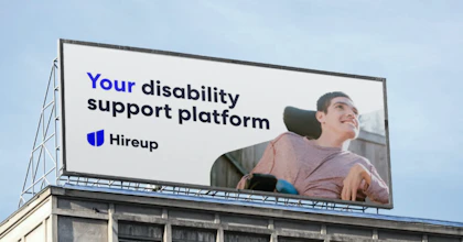 A young man in a wheelchair and the text" your disability support platform" are on a billboard with the Hireup logo.