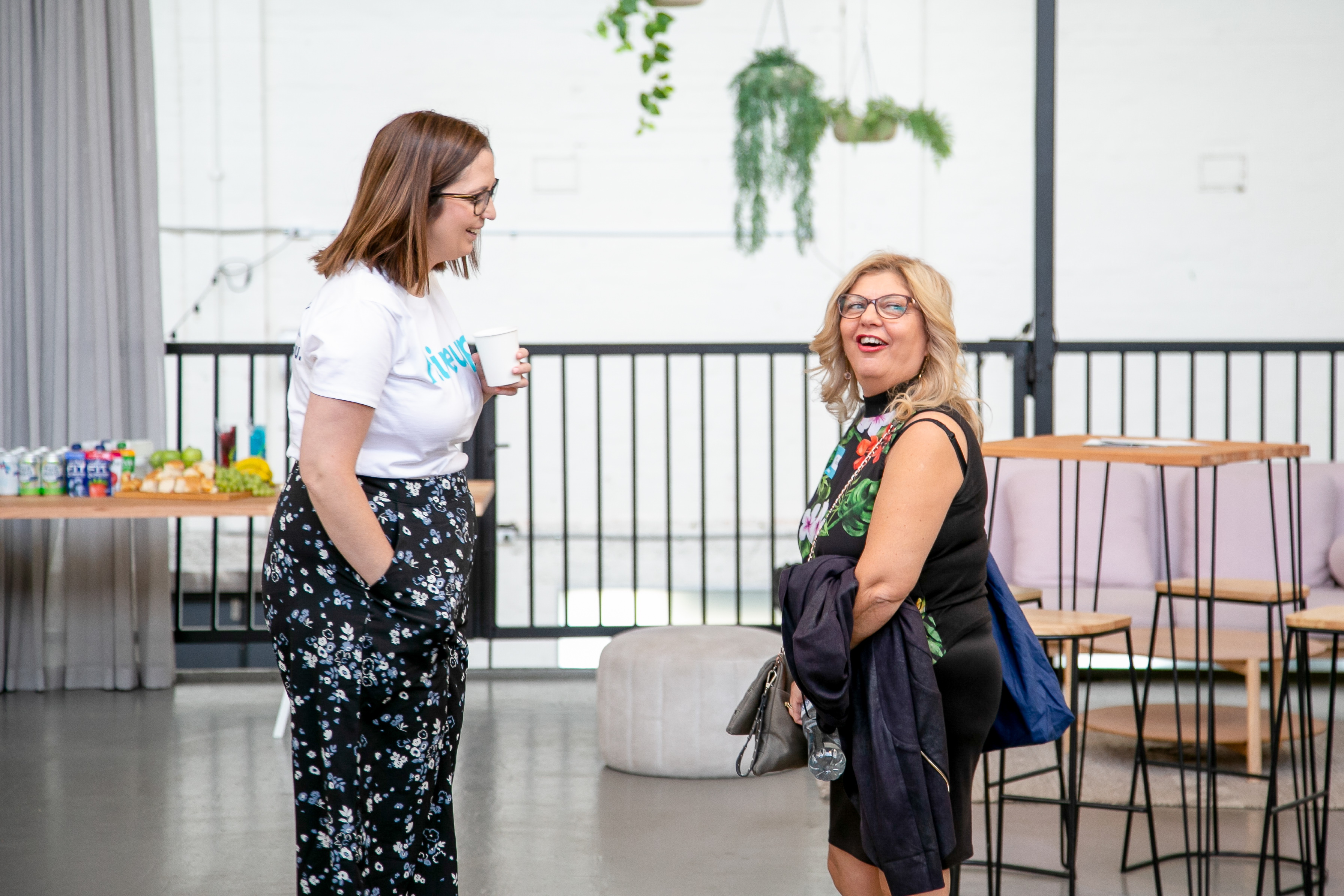 Jess from the Hireup team opposite a support worker as they both laugh and discuss something