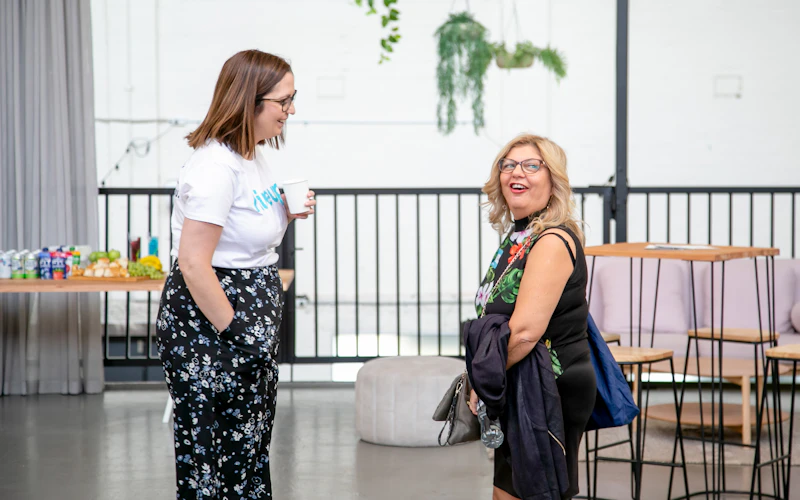 Jess from the Hireup team opposite a support worker as they both laugh and discuss something