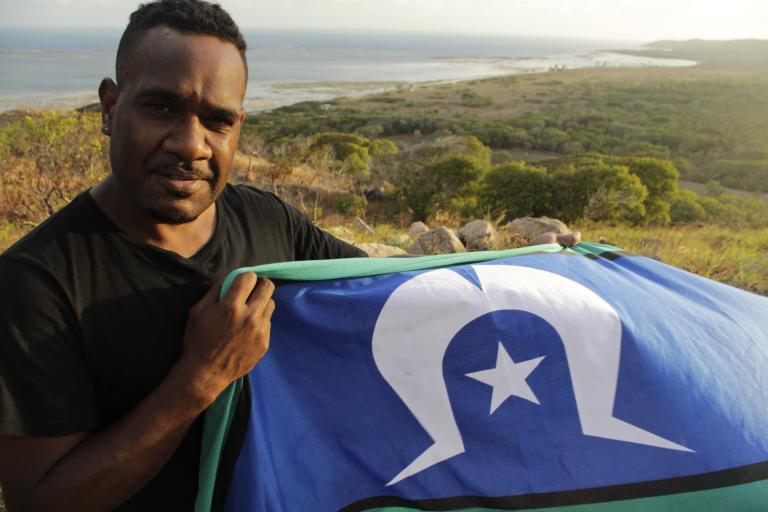 Bernard Namok Jr holds the Torres Strait Islander flag his father, Bernard Namok Sr, designed in 1992. 