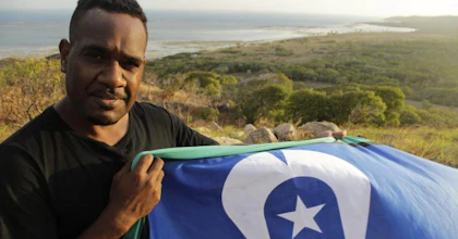 Bernard Namok Jr holds the Torres Strait Islander flag his father, Bernard Namok Sr, designed in 1992.