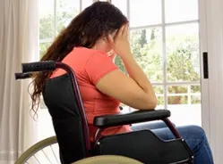 A woman holding her hands over her face, looking upset.