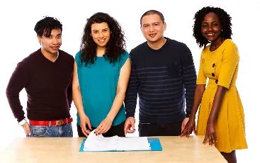 A group of people standing around a document.