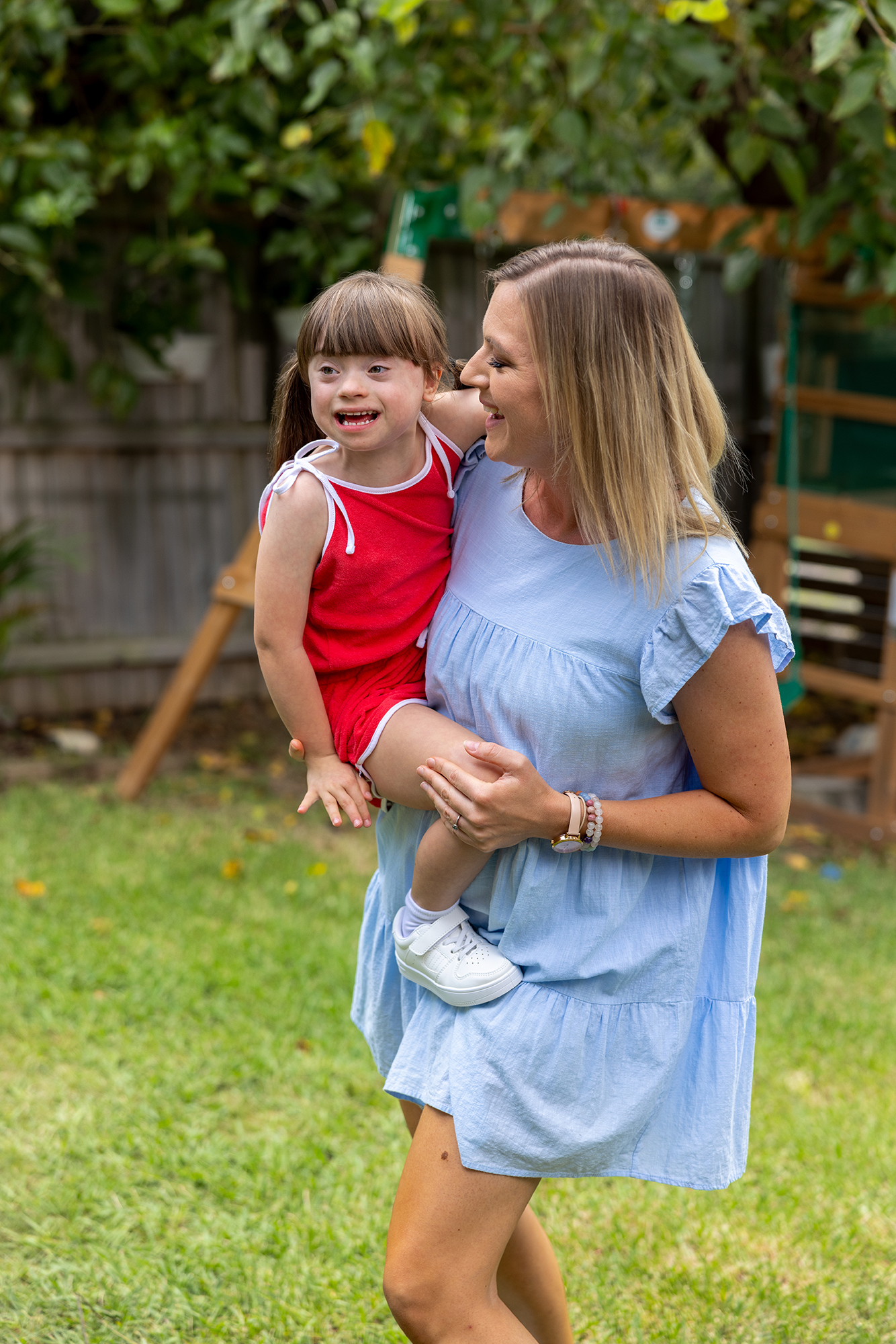 A Hireup user holding her daughter and smiling.
