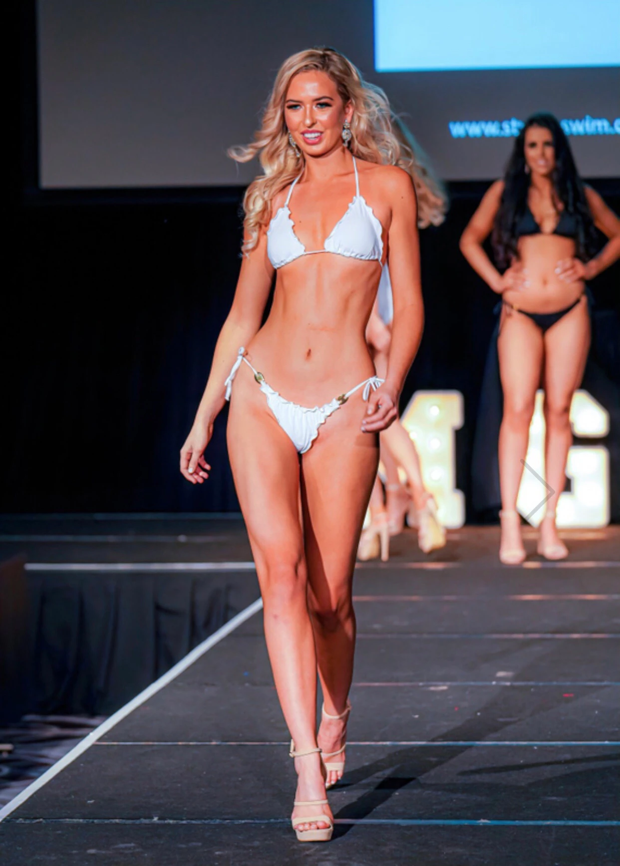 Anja is walking down the catwalk modeling a bikini.