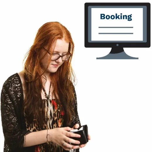 A woman looking in her purse.  She has a booking on a computer screen next to her