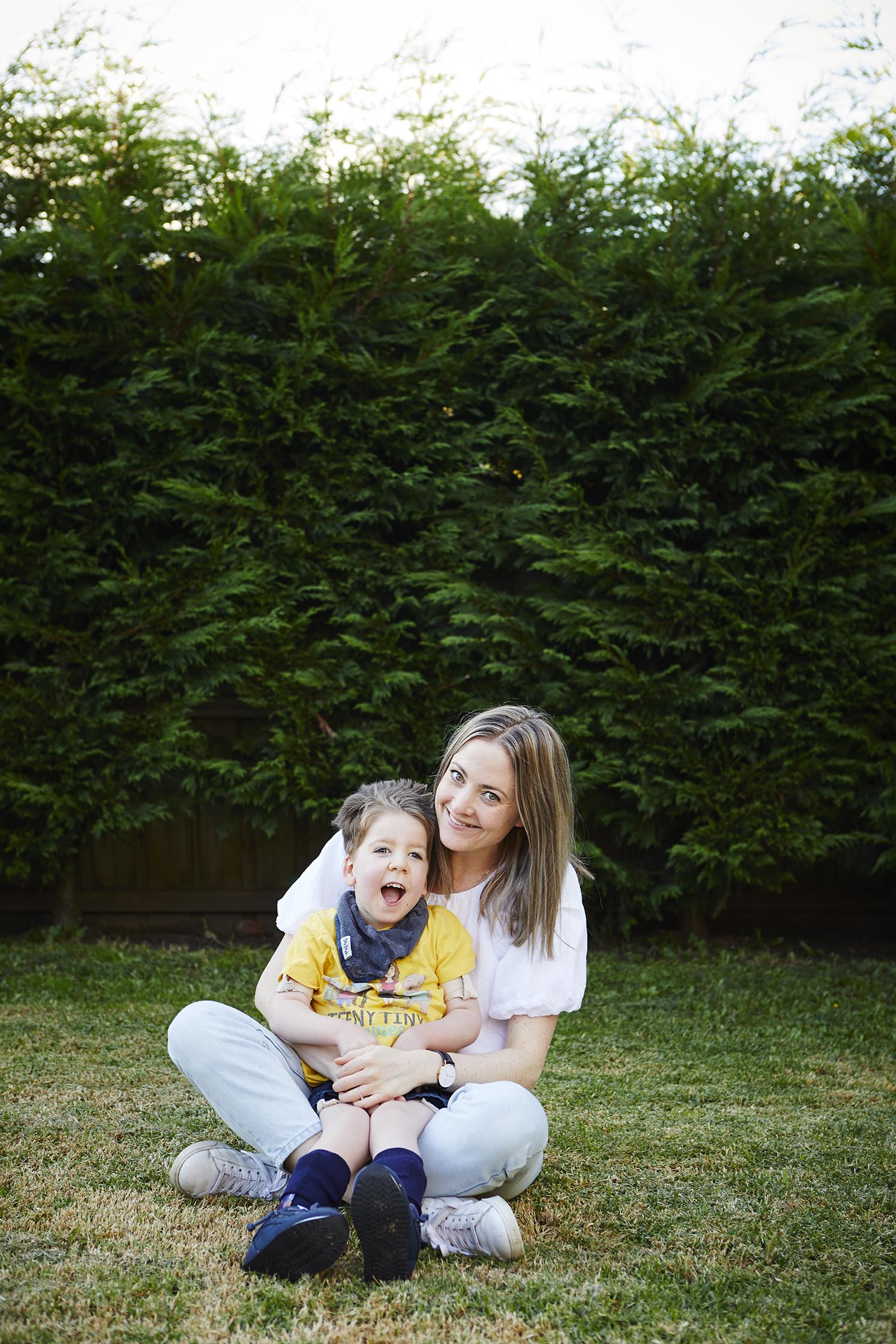 Melanie Dimmitt and her son, Arlo, sit crosslegged together in their garden. 