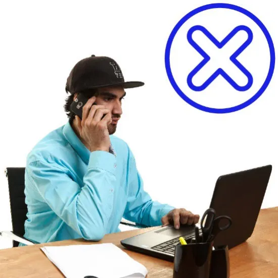 A man on a computer disagreeing with someone on the phone.