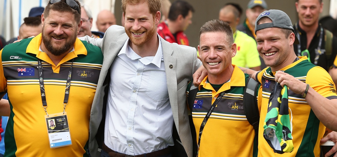 Prince Harry stands with a group of Invictus Games athletes. 