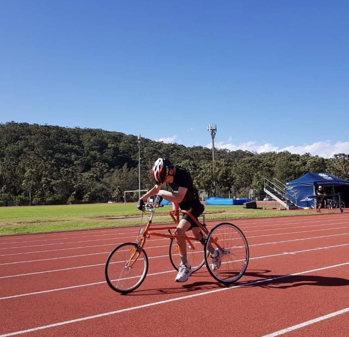 Andrew is mid race as he is racing his bike at the racetrack.