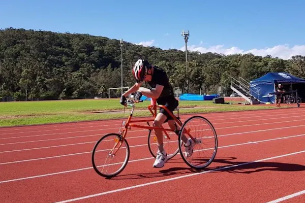 Andrew is mid race as he is racing his bike at the racetrack.