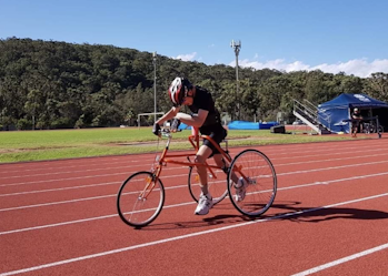 Andrew is mid race as he is racing his bike at the racetrack.