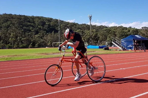 Andrew is mid race as he is racing his bike at the racetrack.