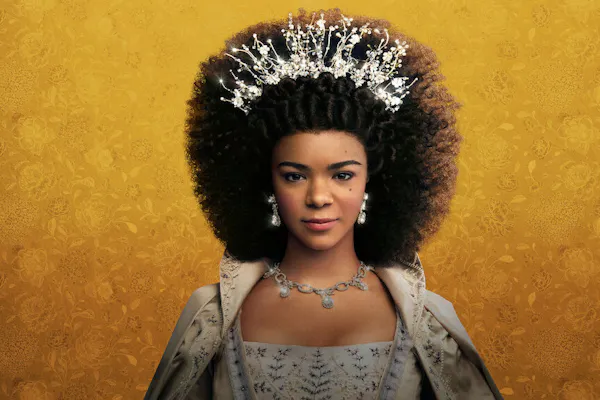 Queen Charlotte is a character in a Netflix series, which this image promotes. A dark-skinned woman dressed in regal attire and wearing a crown is featured in font of a yellow background.