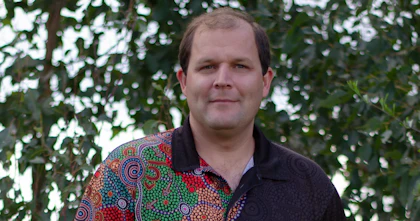 John Gilroy is looking at the camera smiling.