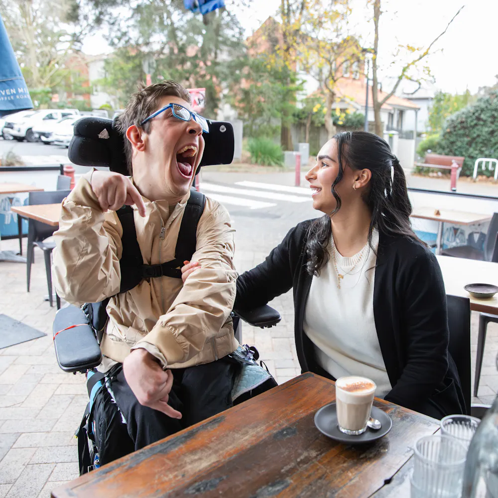 Hireup client Al with his support worker Bec at a cafe.