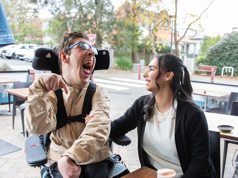 Hireup client Al with his support worker Bec at a cafe.