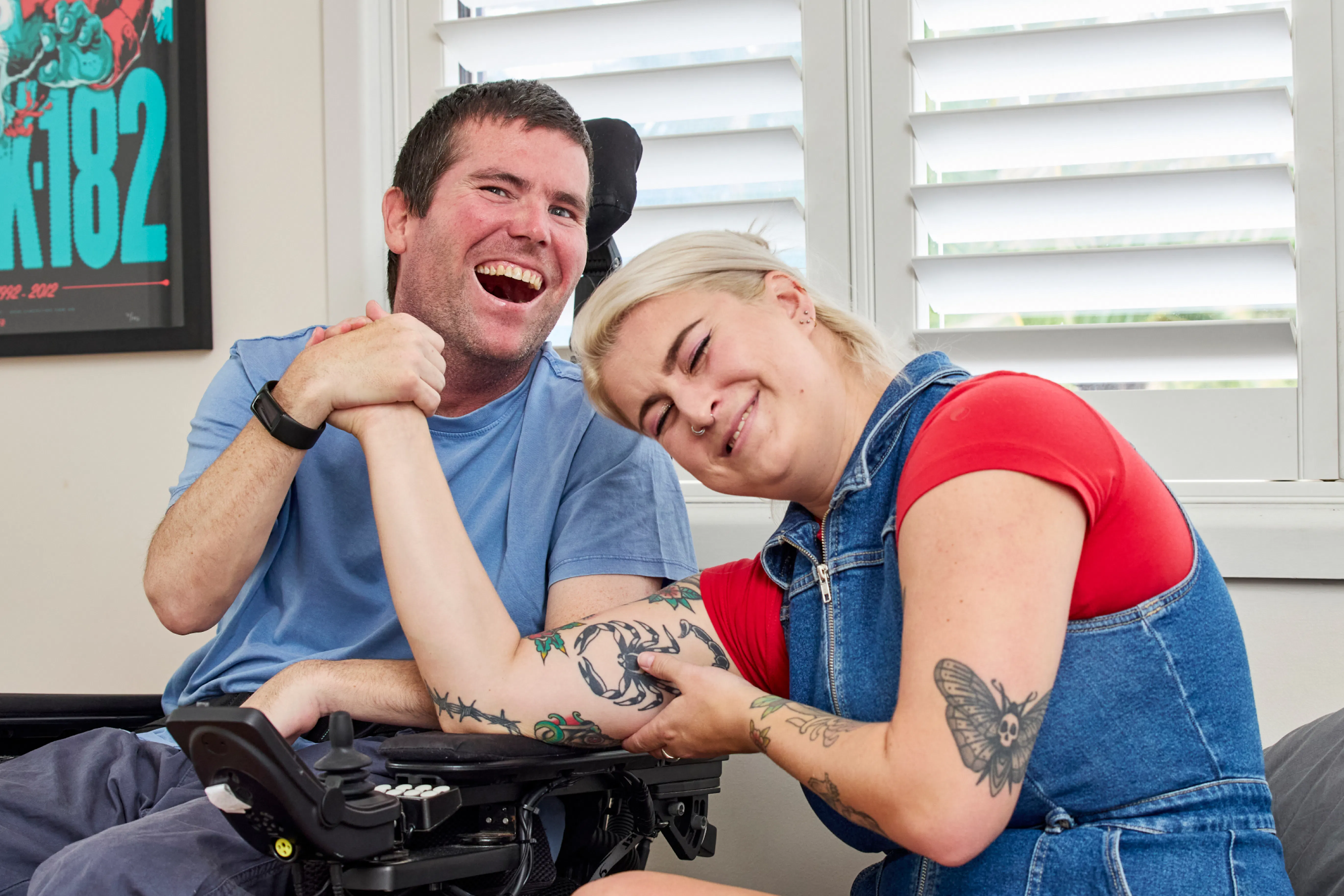 Client Mick and support worker Maddy laughing together.