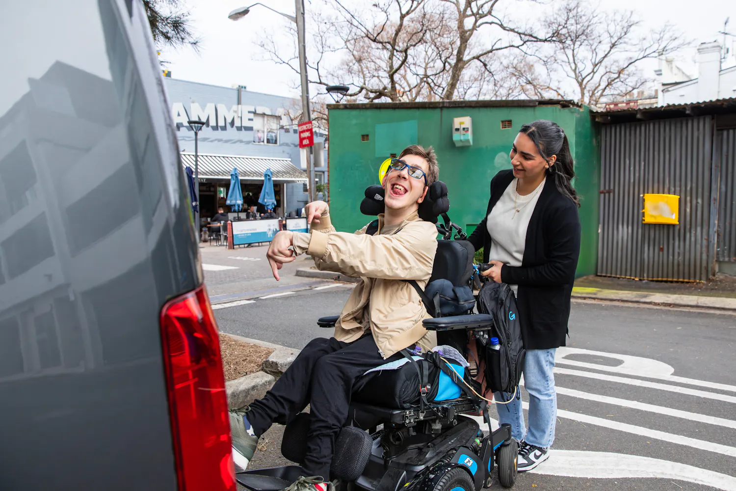 Support worker Bec helps client Al into the car in his wheelchair.
