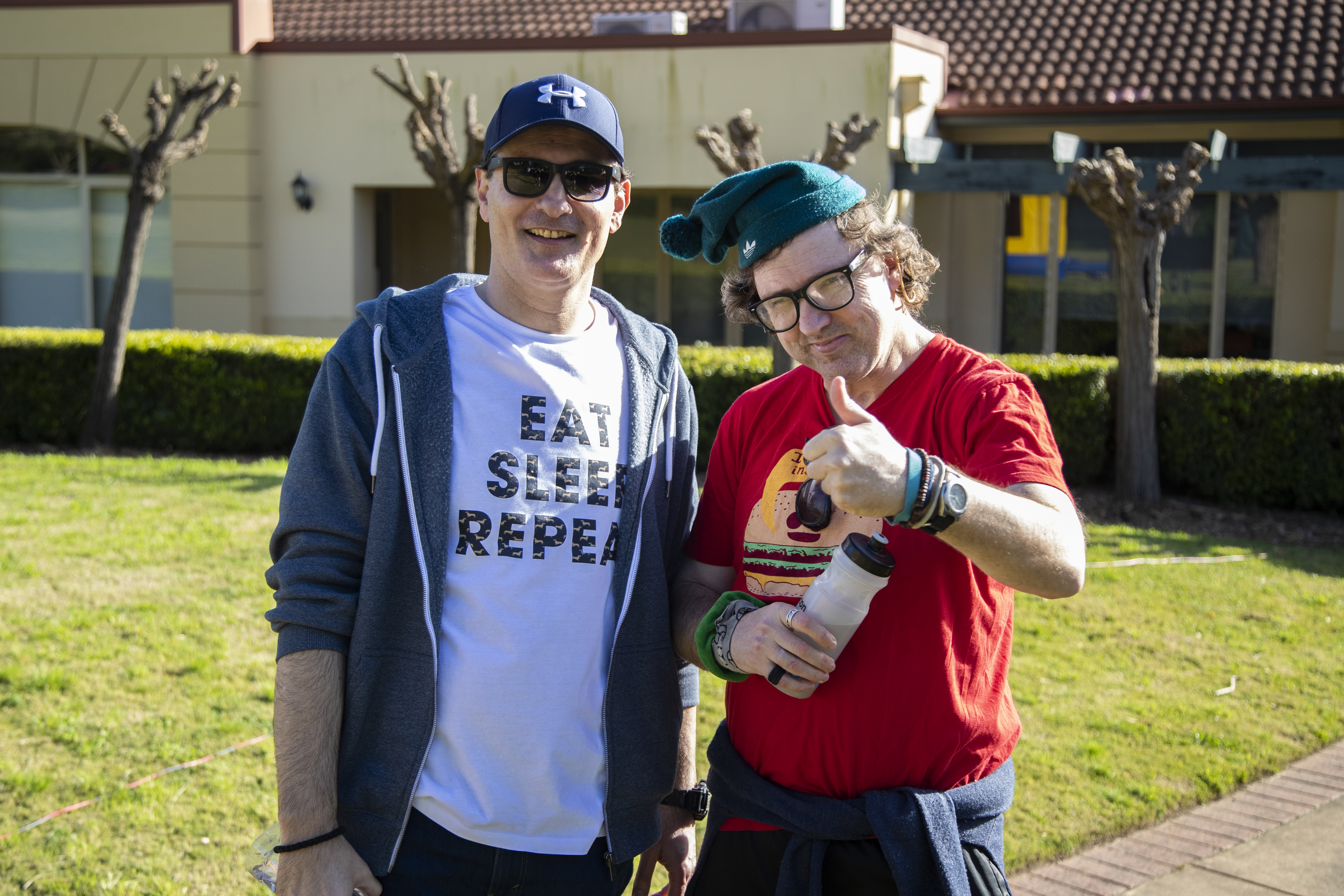 A Hireup client gives the thumbs up to the camera next to his support worker.