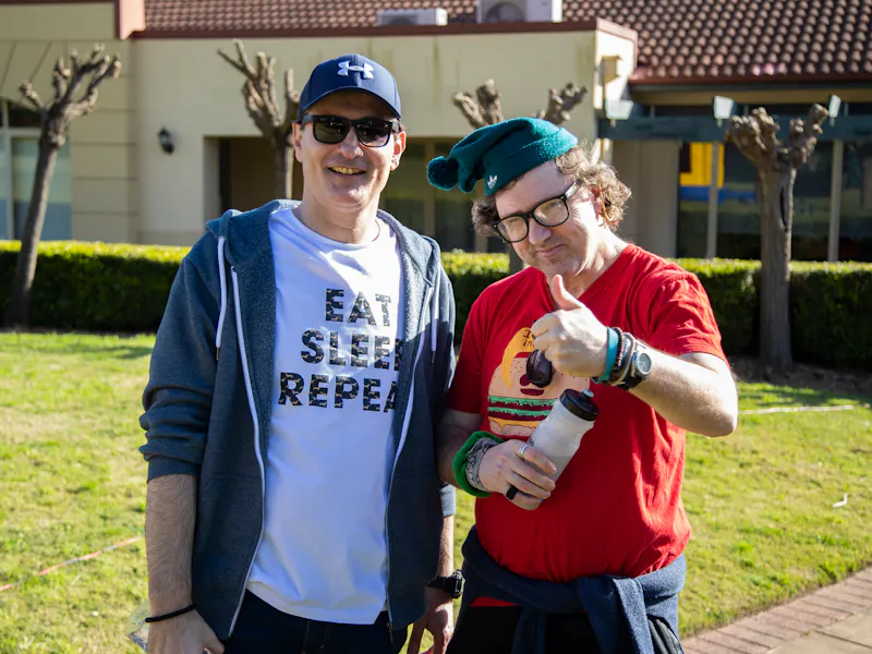 A Hireup client gives the thumbs up to the camera next to his support worker.