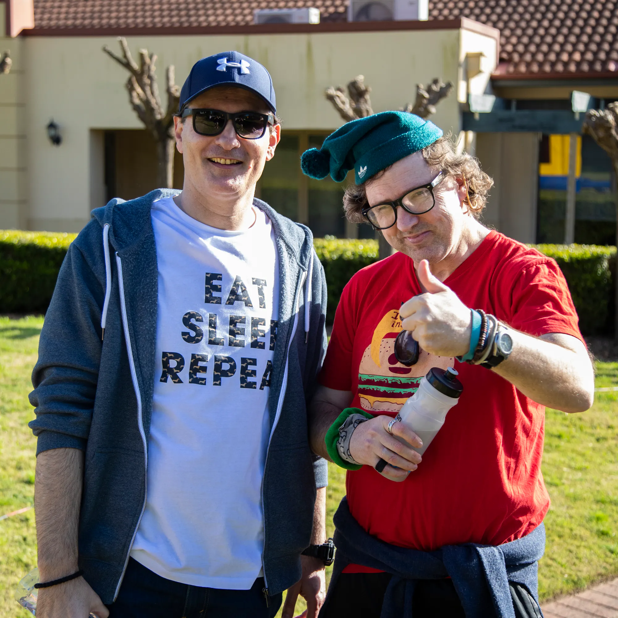 A Hireup client gives the thumbs up to the camera next to his support worker.