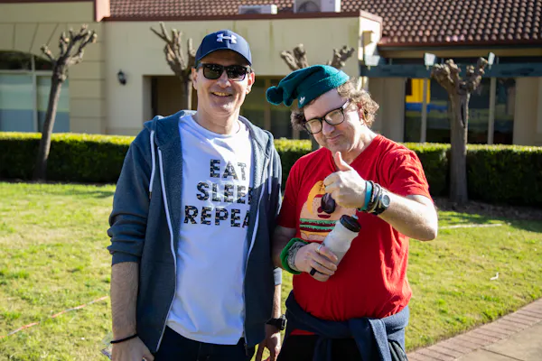 A Hireup client gives the thumbs up to the camera next to his support worker.