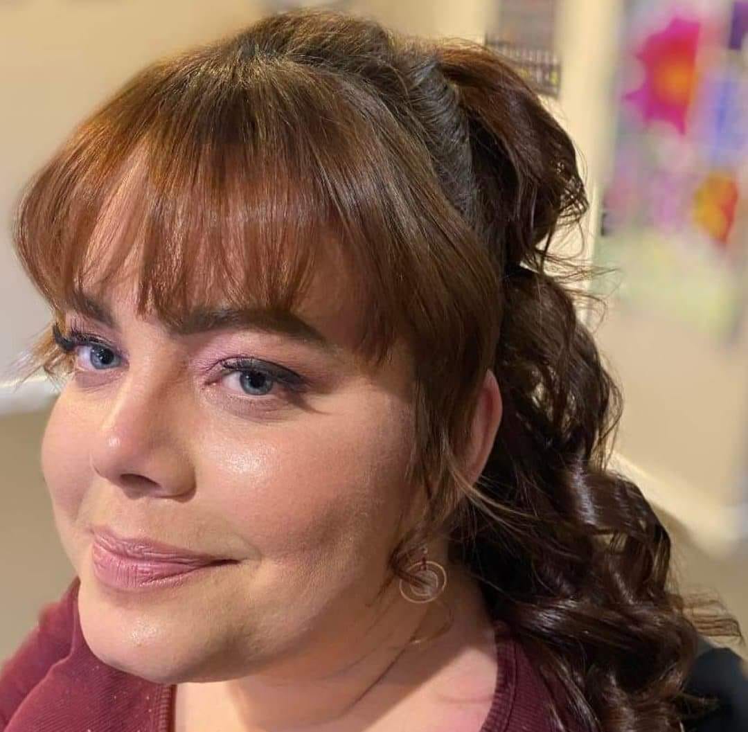 Disability advocate and writer, Nicole Smith, has long brown hair and blue eyes. She smiles at the camera.