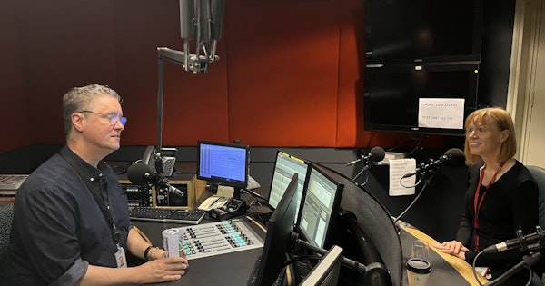 Image show Briana Blackett in an ABC radio studio with host, Richard Fidler. Both are seated opposite each other, speaking into microphones.