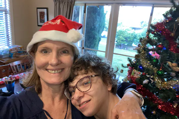 Lisa Grech stands cuddling her daughter in their living room at Christmas time.