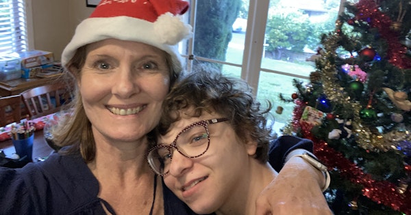 Lisa Grech stands cuddling her daughter in their living room at Christmas time.