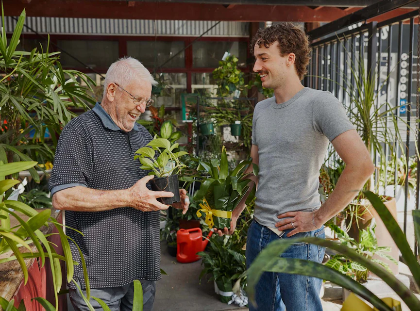 Hireup client Frank and worker Luca pick pot plants up from a nursery.