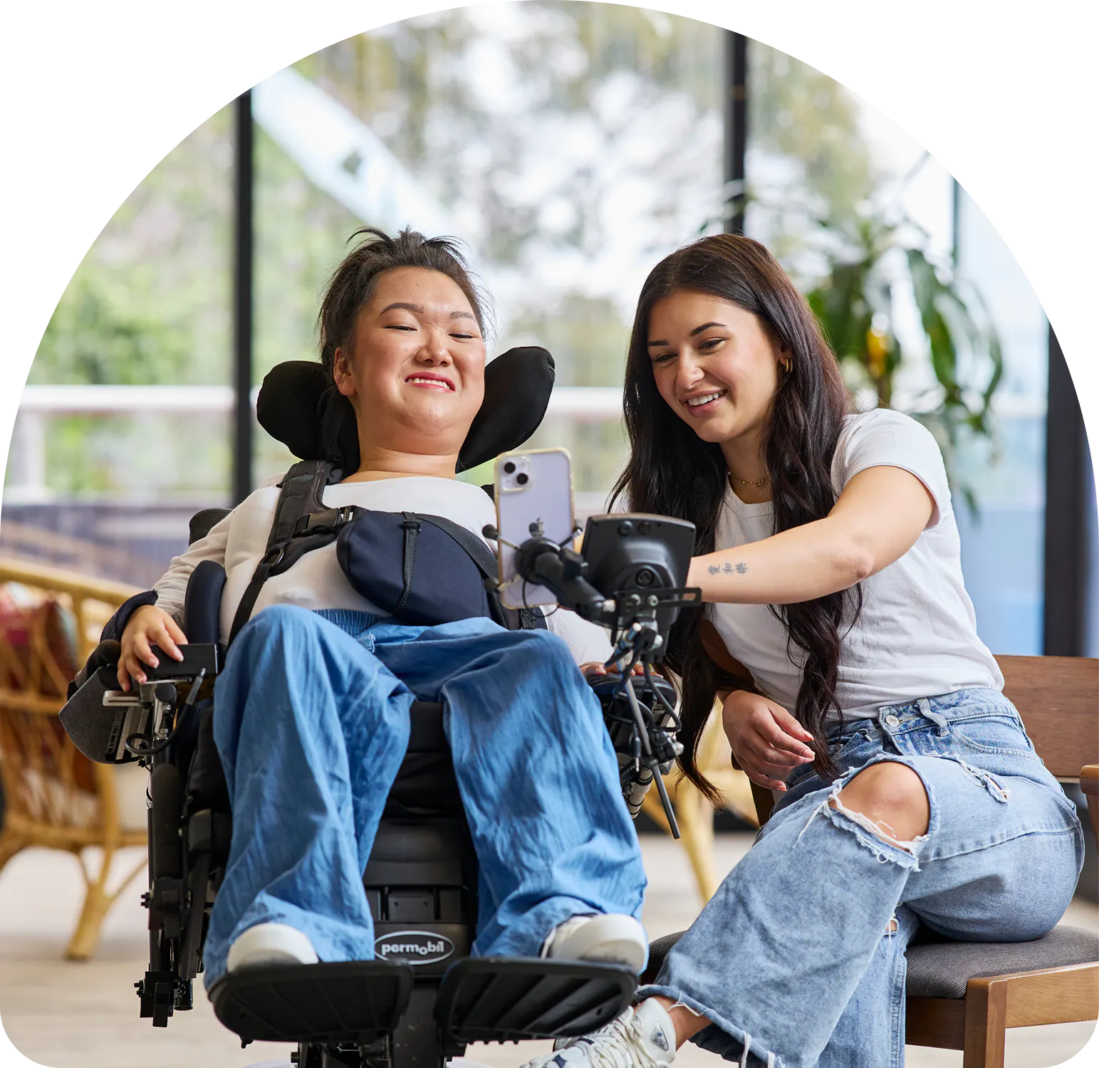 Hireup client Mel uses her phone with assistance from support worker Allyah.