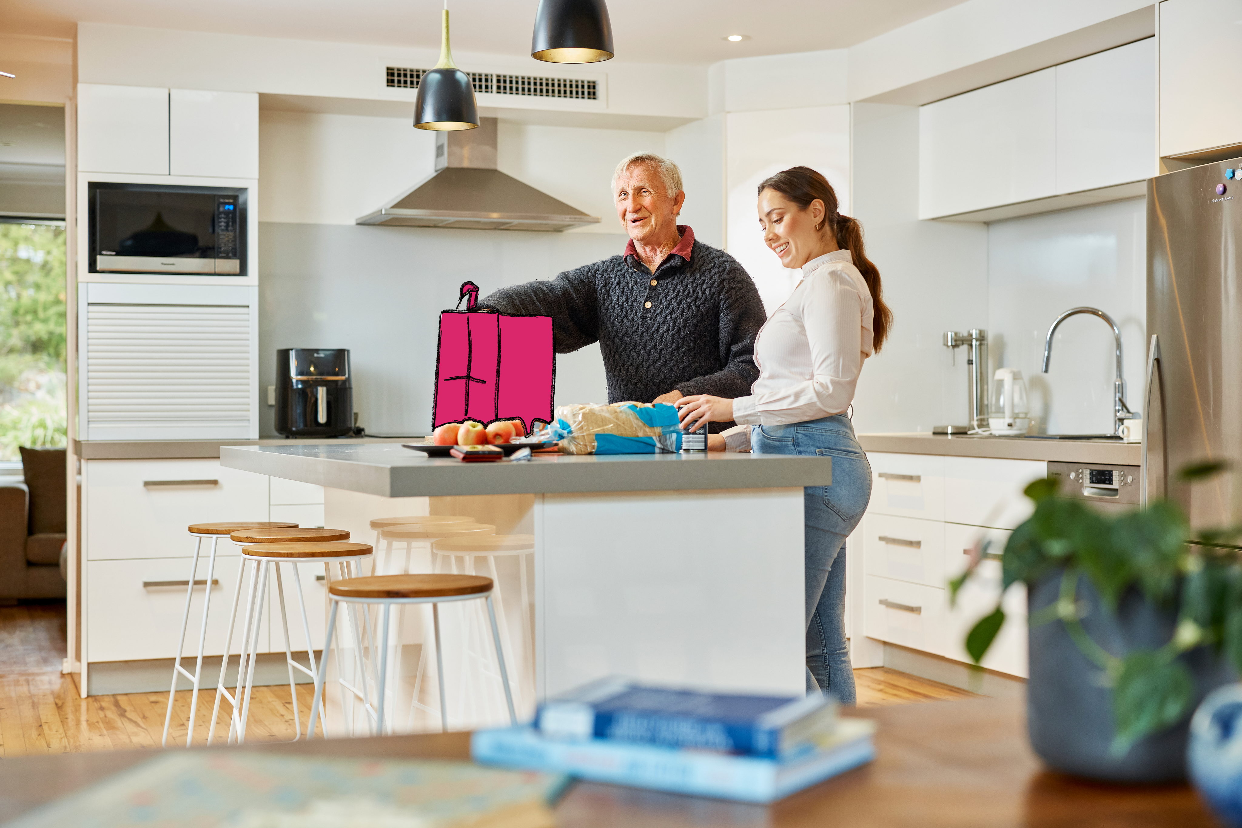 Hireup client Dirk and support worker Brenda unpack groceries on his kitchen bench.